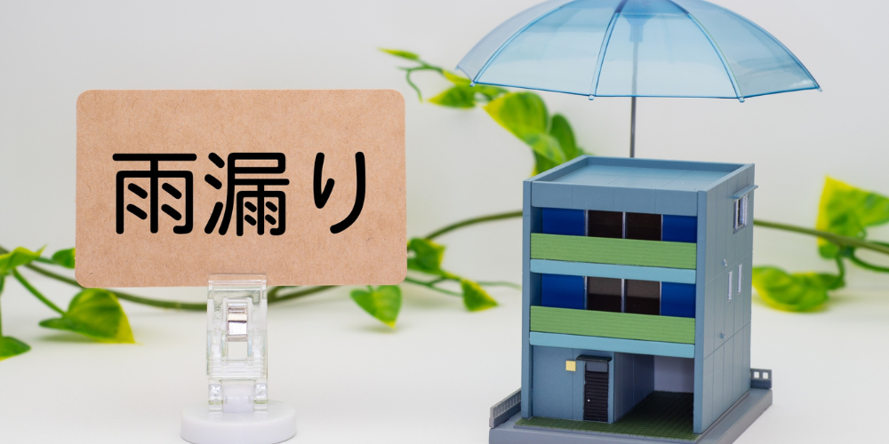 『雨漏り』と書かれた札と、青い傘で保護された3階建ての家
