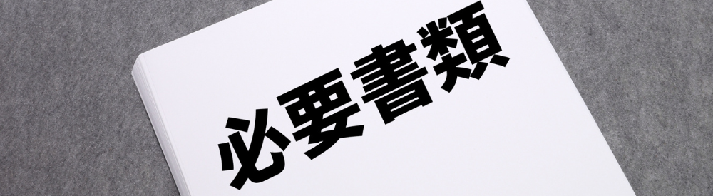 「必要書類」と太字で印刷された白い書類の束