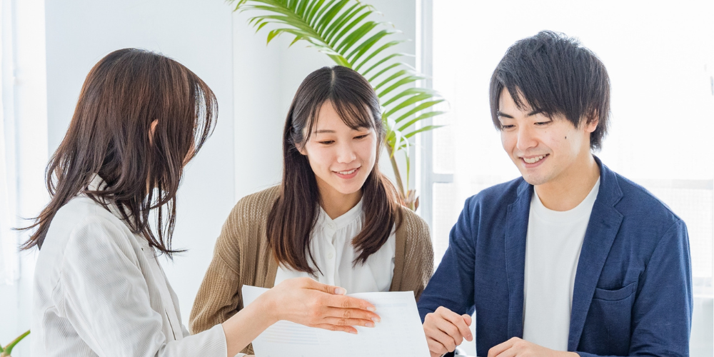 木目調の背景に並べられた“MERIT”の立体文字