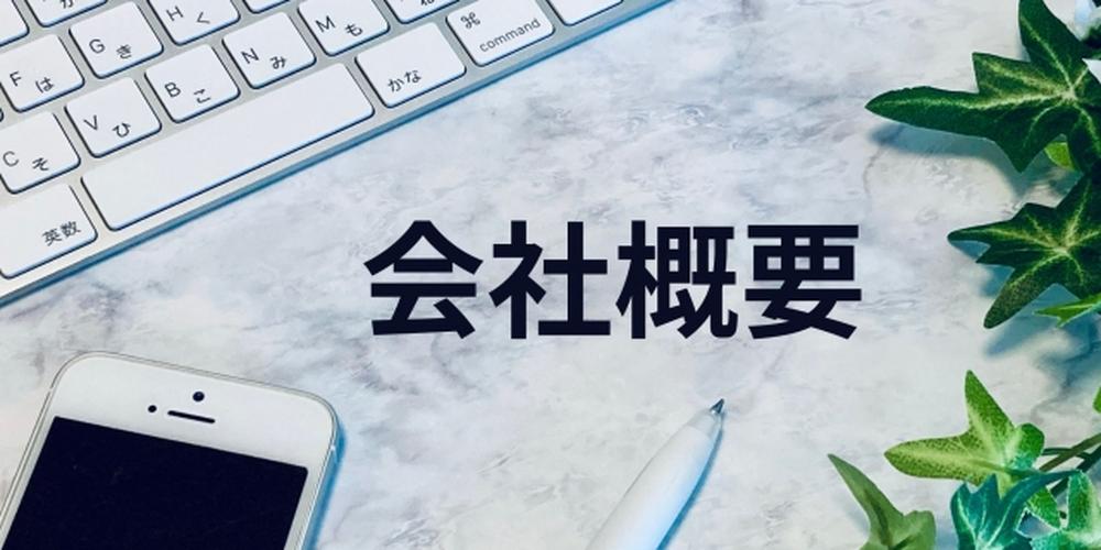 パソコンのキーボードとスマートフォンのそばに「会社概要」