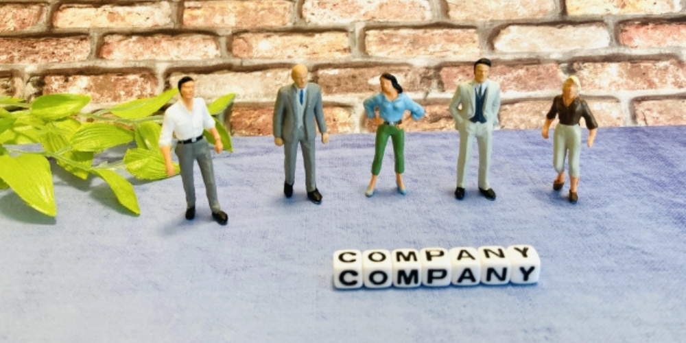 「COMPANY」の文字と並ぶスーツ姿のフィギュア人形たちの集合