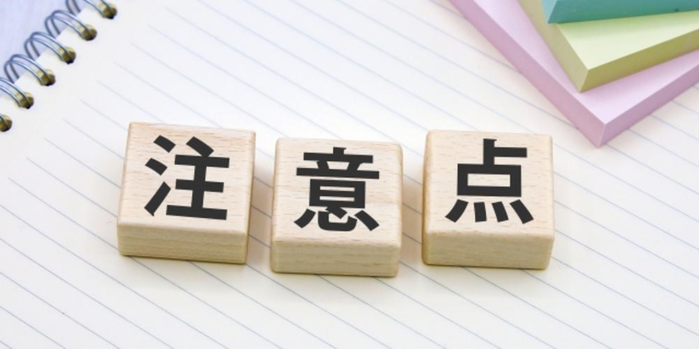 ノートの上に「注意点」と書かれた木製ブロックが並んでいる画像
