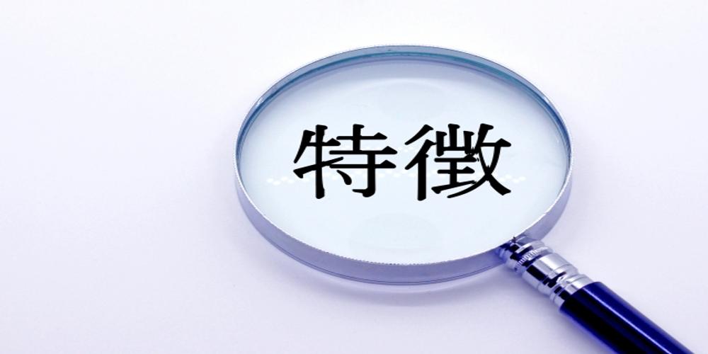 虫眼鏡の中に『特徴』の文字が映る画像、企業やサービスの特性や強みを象徴するビジュアル