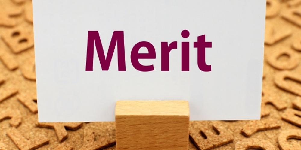 『Merit』と書かれたカードが木製スタンドに立てられている