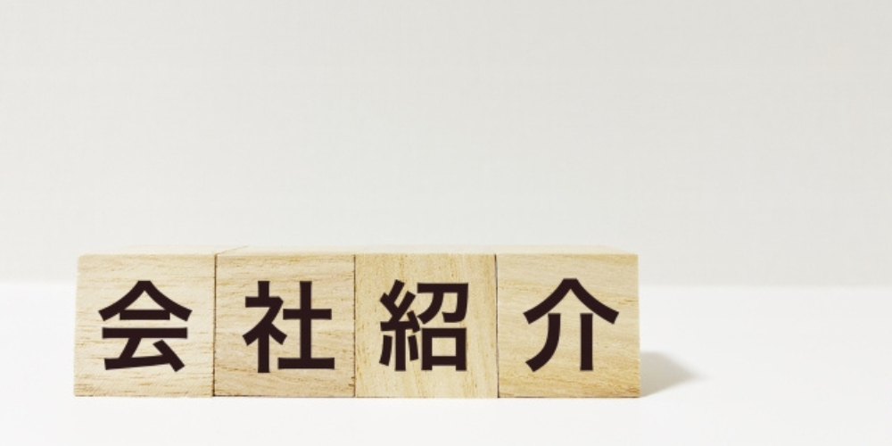 「会社紹介」と書かれた木製ブロックが並んでおり、シンプルな背景が特徴の紹介用ビジュアル。