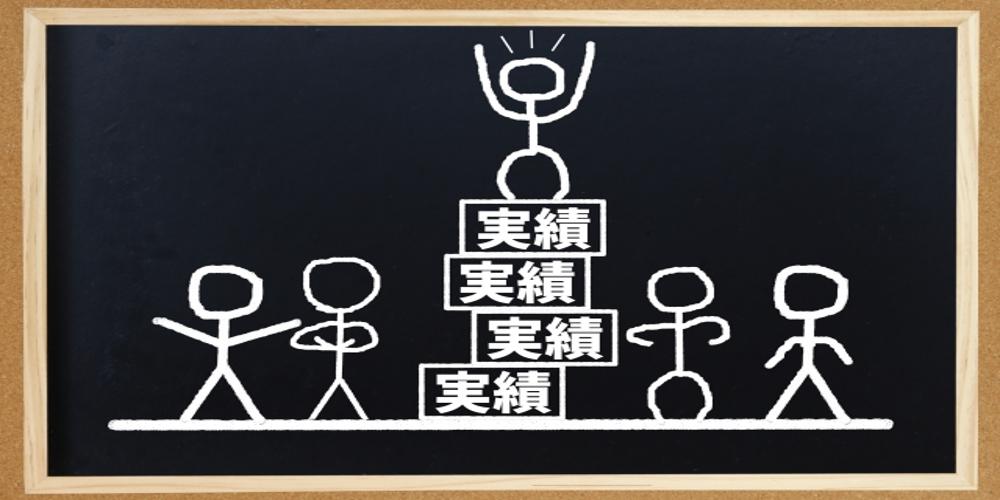 黒板に書かれた棒人間と『実績』の文字、チームの協力と実績の積み重ねを象徴するビジュアル