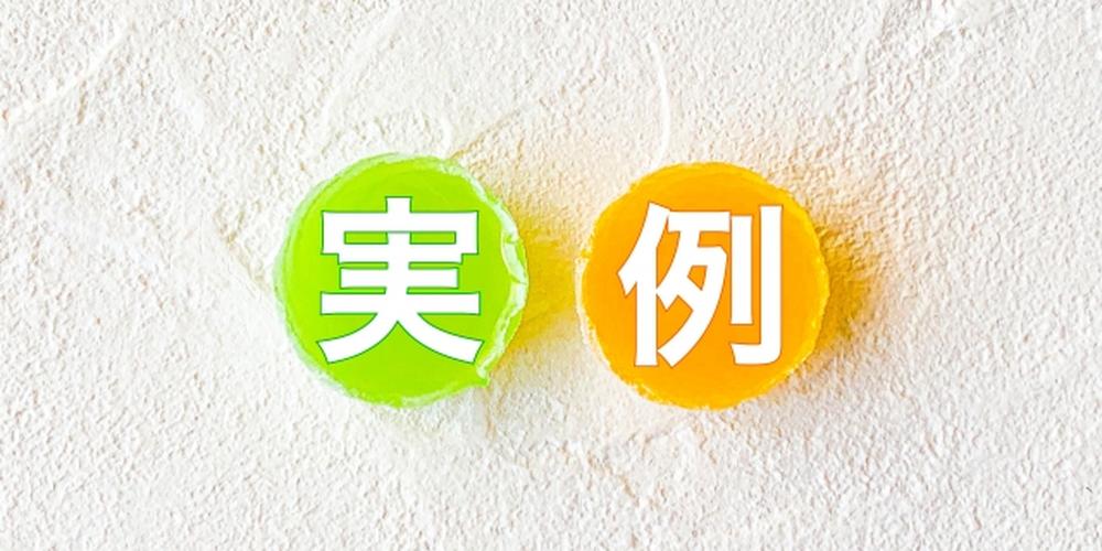 白い壁面に緑とオレンジのゼリー状の丸があり、それぞれに「実」「例」の文字