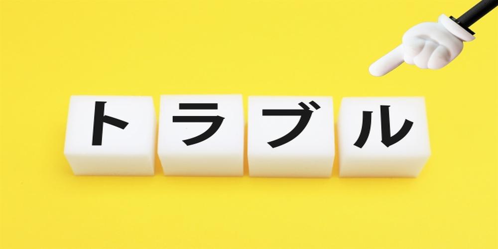 黄色い背景に並べられた『トラブル』の文字と指差しマークのイメージ