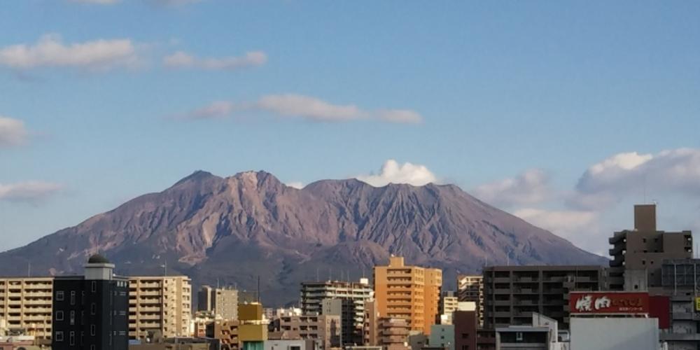街並みの向こうにそびえる桜島の雄大な風景