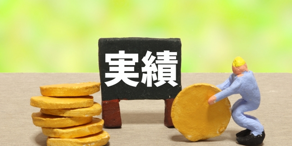 実績の文字とコインを運ぶ人形