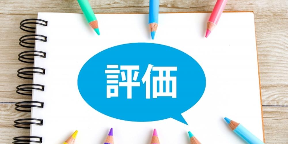 ノート中央に青い吹き出しで「評価」と書かれ、その周囲を色鉛筆が囲んでいる構図