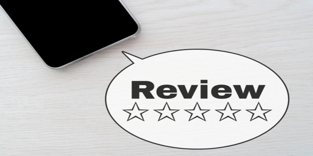 スマートフォン横に置かれた『Review』と星評価の吹き出し、顧客の評価やレビューを示すイメージ