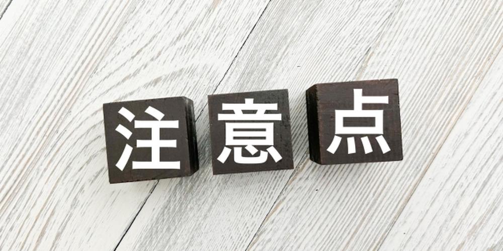 木目調の背景上に置かれた『注意点』と書かれた黒いキューブブロック