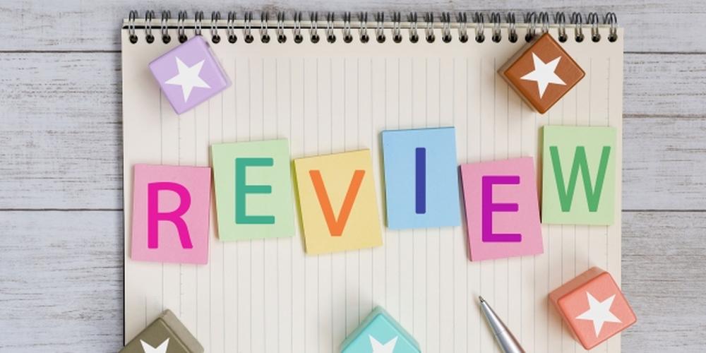 ノートの上に「REVIEW」と書かれたカラフルな文字カードと星