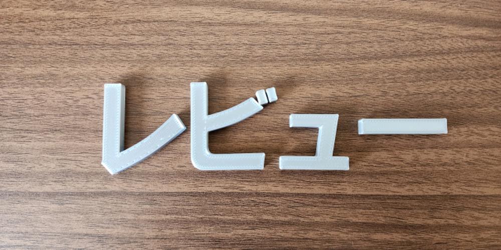 木目の背景に「レビュー」と書かれた文字が置かれており、口コミや評価を連想させるシンプルな構図。