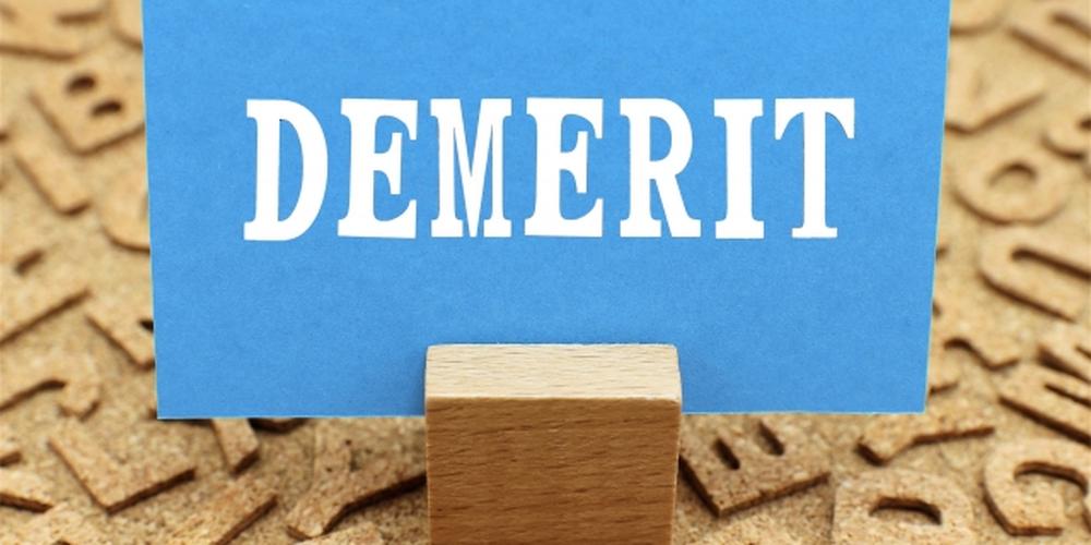 コルクボードの背景に「DEMERIT」