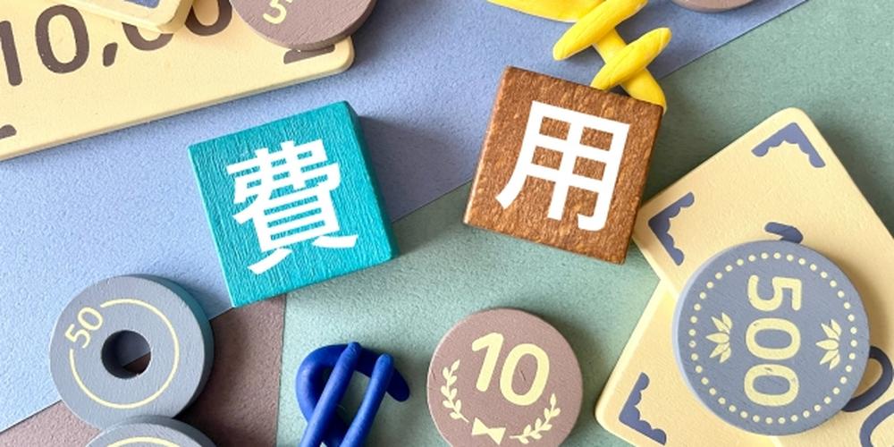 費用」と書かれた積み木とお金をイメージしたアイテムが並んでいる