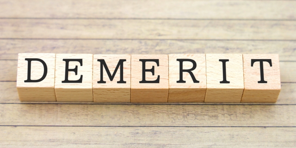 木のブロックで並べられた“DEMERIT”の文字