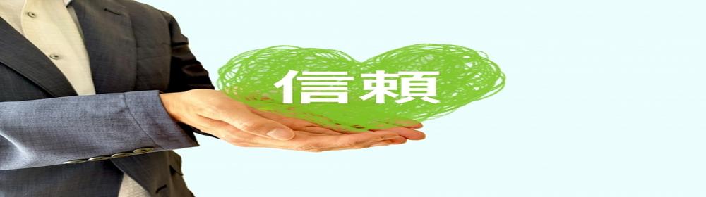 信頼を象徴する緑のハートを手に持つビジネスマンのイメージ