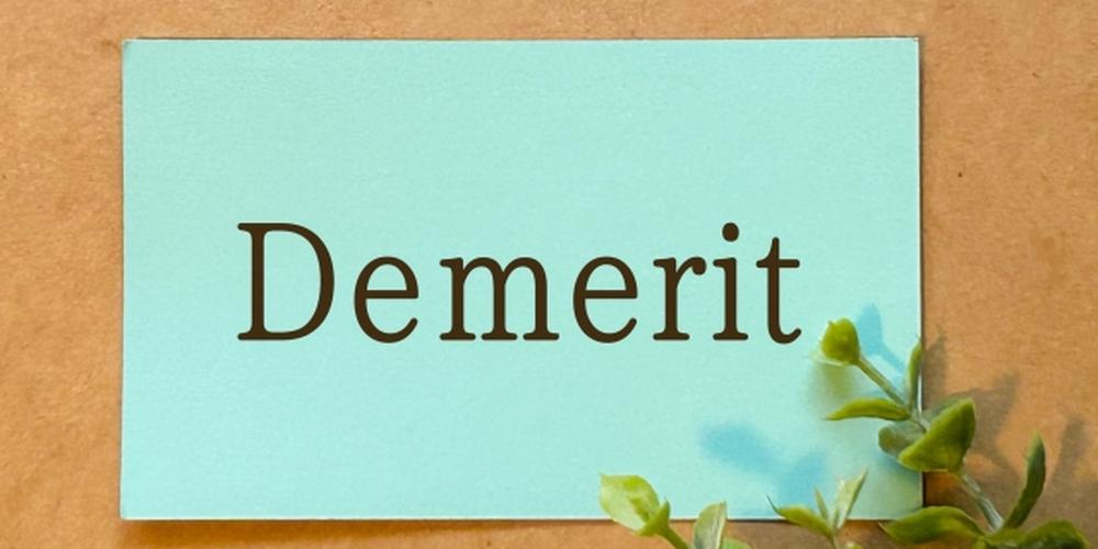 クラフト紙の上に置かれた青いカードに「Demerit」