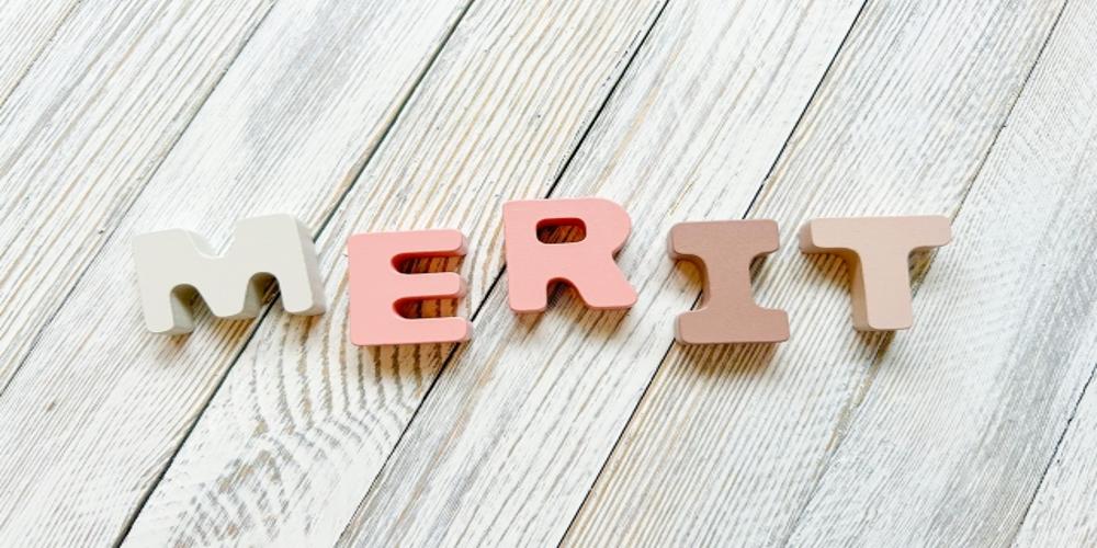 木製ブロックで構成された『MERIT』の文字、企業やサービスの利点を象徴するビジュアル
