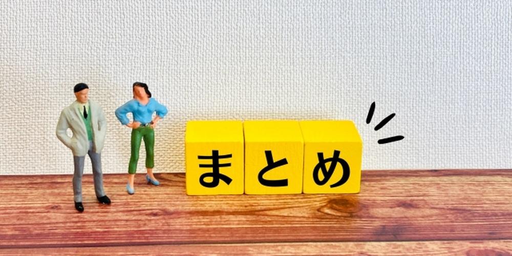 木目の床に黄色いキューブで「まとめ」と書かれ、その横にミニチュアの男女フィギュアが立っている。