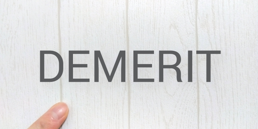 白い木目の背景に「DEMERIT」