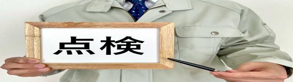 点検と書かれたボードを持つ作業着姿の人物