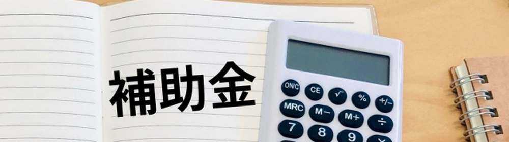 ノートに書かれた『補助金』の文字と電卓｜補助金制度や経費支援に関するイメージ