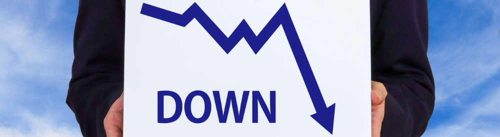 「DOWN」の文字が書かれたボードを持つビジネスマン